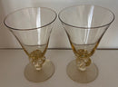 Two clear glass goblets with gold bases